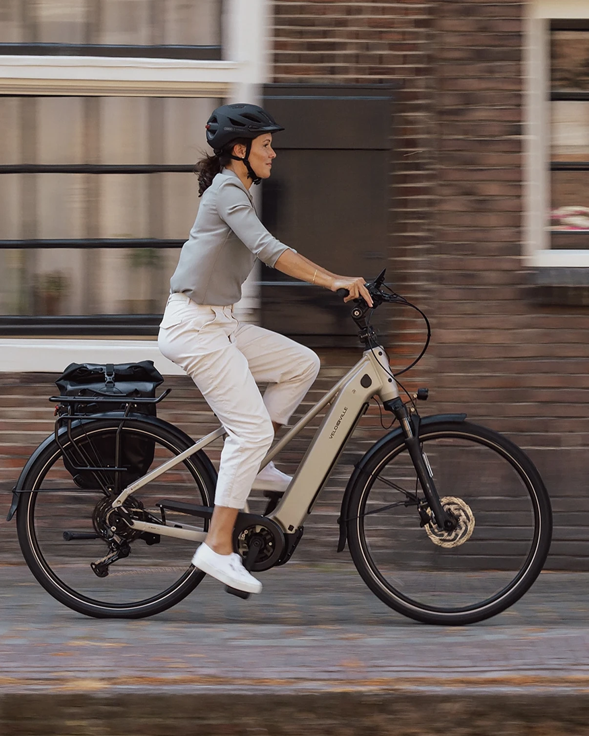 Cycliste en tenue de ville sur un vélo à assistance électrique en milieu urbain